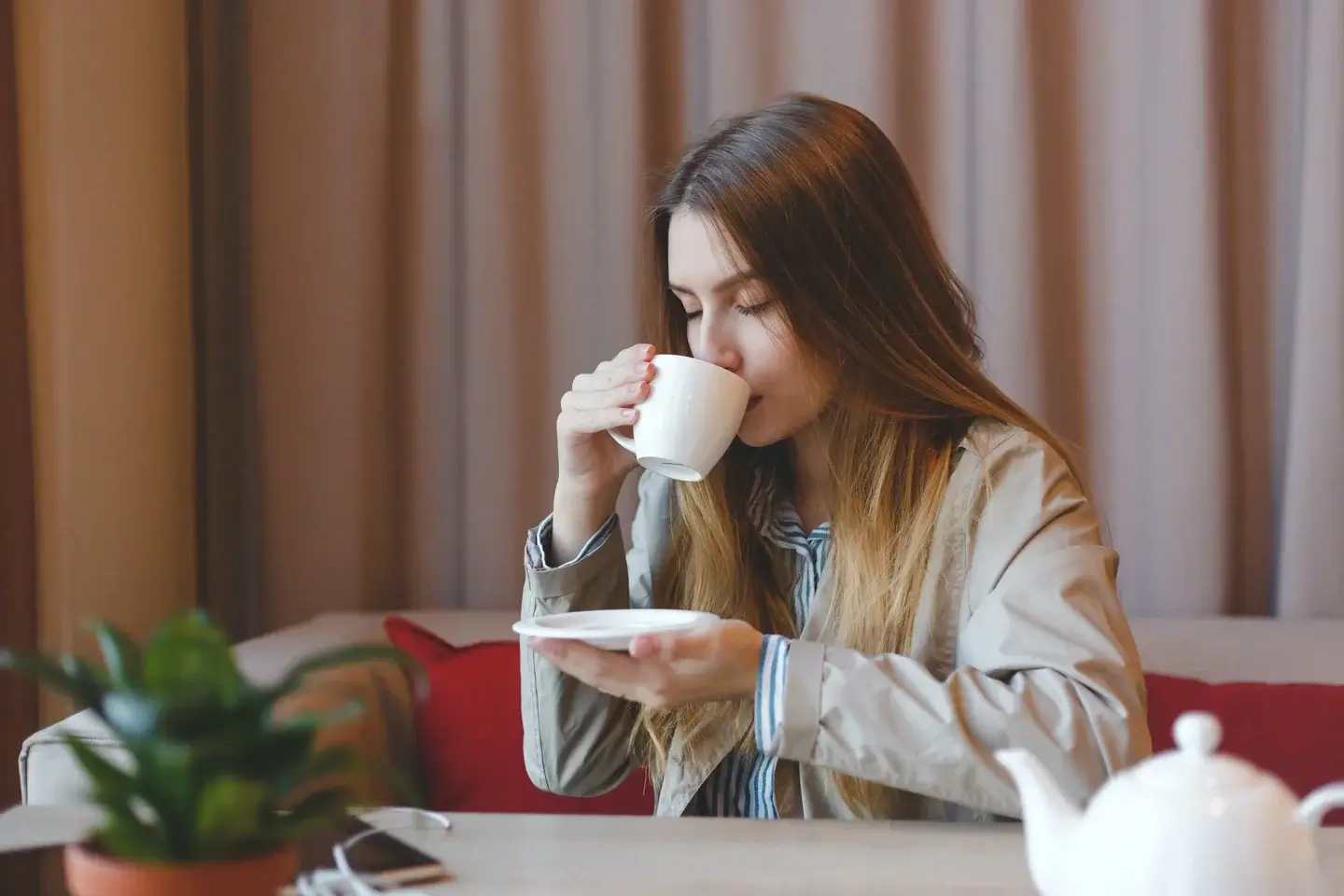 Kobieta pijąca kawę.Pokazuje, że odpowiednia organizacja pracy w domu powoduje znalezienie czasu na odpoczynek i czas wolny.